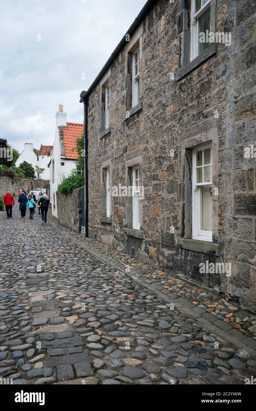 Tourists walk along a cobblestone lane in a tiny village, Culross, Fife, Scotland, UK, Europe Stock Photo
