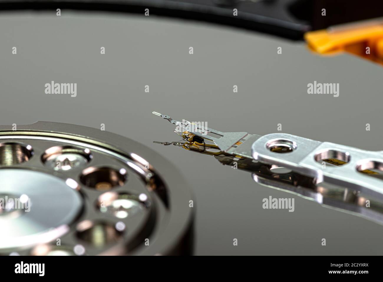Macro shot of a magnetic needle on a hard disk platter, open HDD disk, perfectly clean surface. Stock Photo