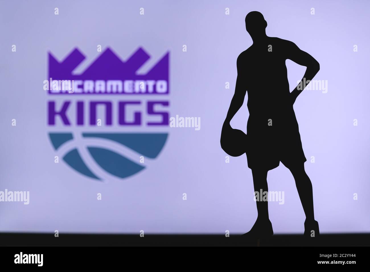 NEW YORK, USA, JUN 18, 2020: Sacramento Kings logo of professional basketball club in american league. Silhouette of basket player in foreground. Spor Stock Photo
