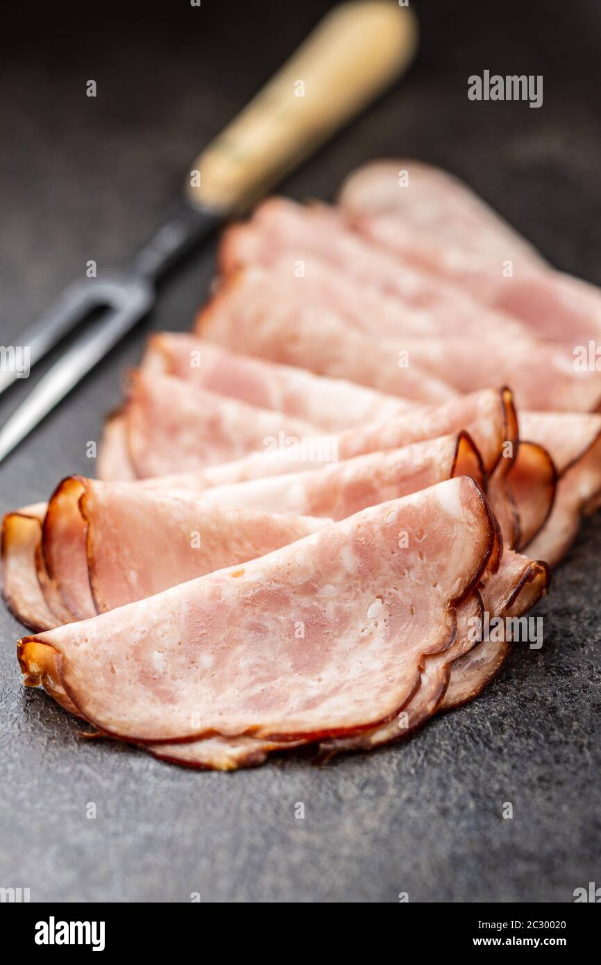 Sliced salami sausage. Smoked ham on old kitchen table. Stock Photo