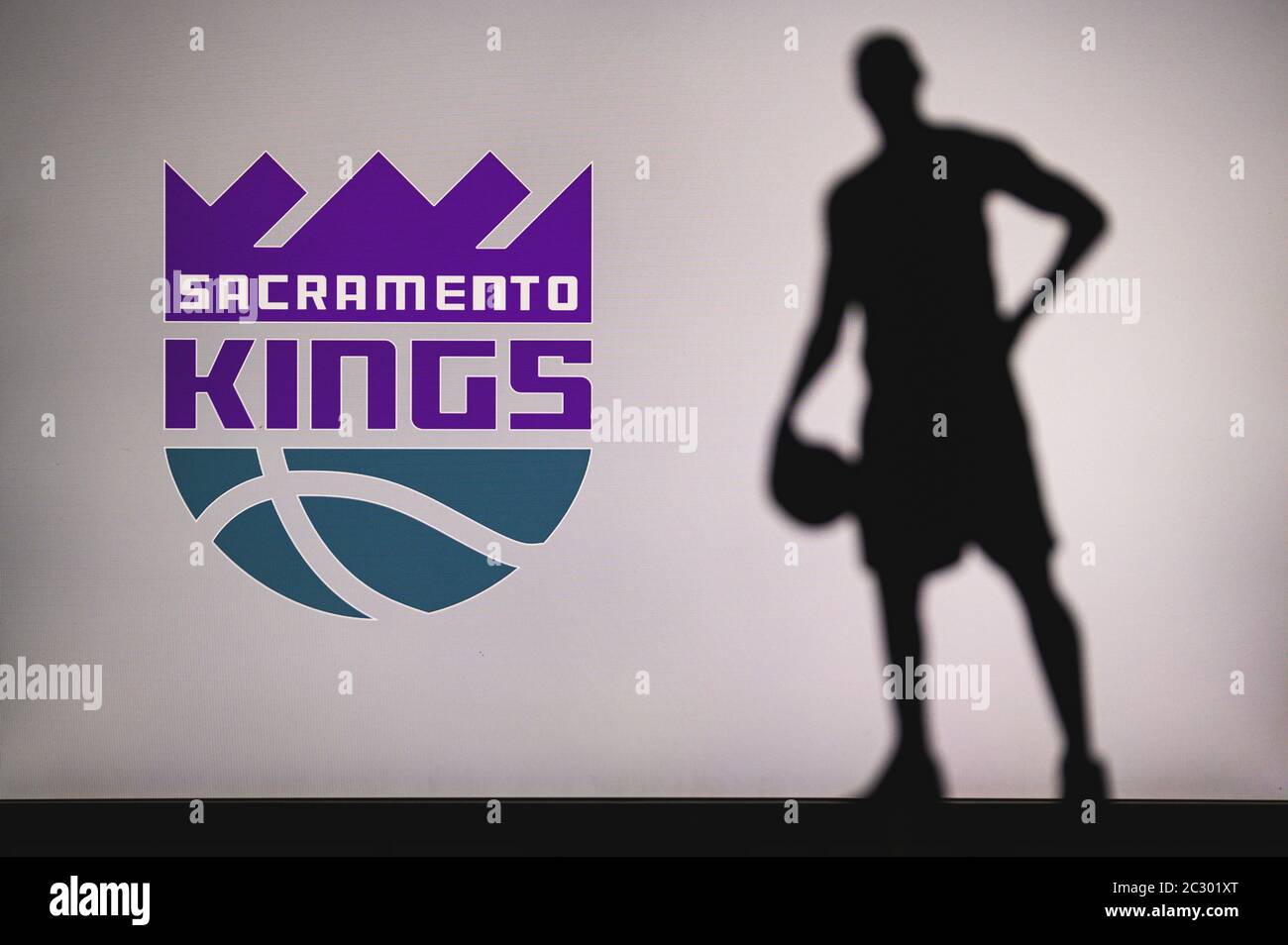 NEW YORK, USA, JUN 18, 2020: Sacramento Kings logo of professional basketball club in american league. Silhouette of basket player in foreground. Spor Stock Photo