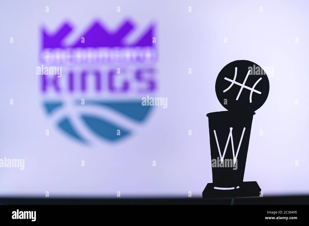 NEW YORK, USA, JUN 18, 2020: Sacramento Kings Basketball club on the white screen. Silhouette of NBA trophy in foreground. Stock Photo