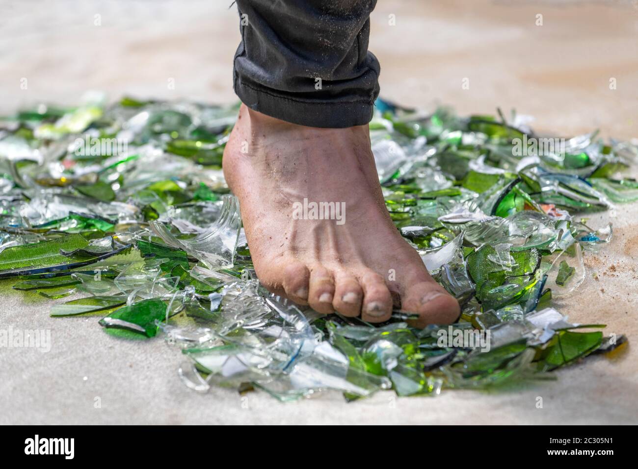 Fakir with foot walking over broken glass, Rinteln, Germany Stock Photo