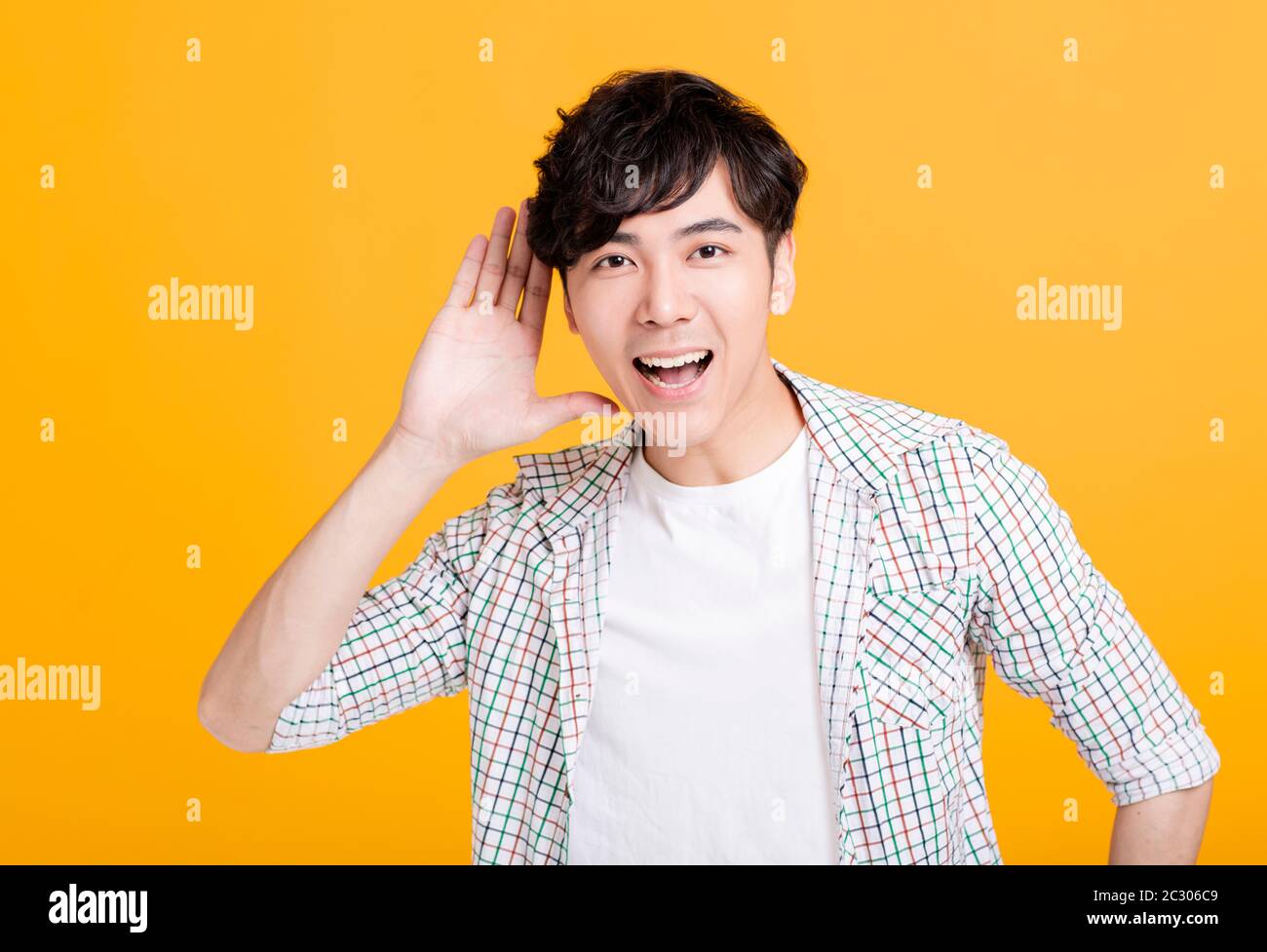 young man  with hand over ear listening and hearing Stock Photo