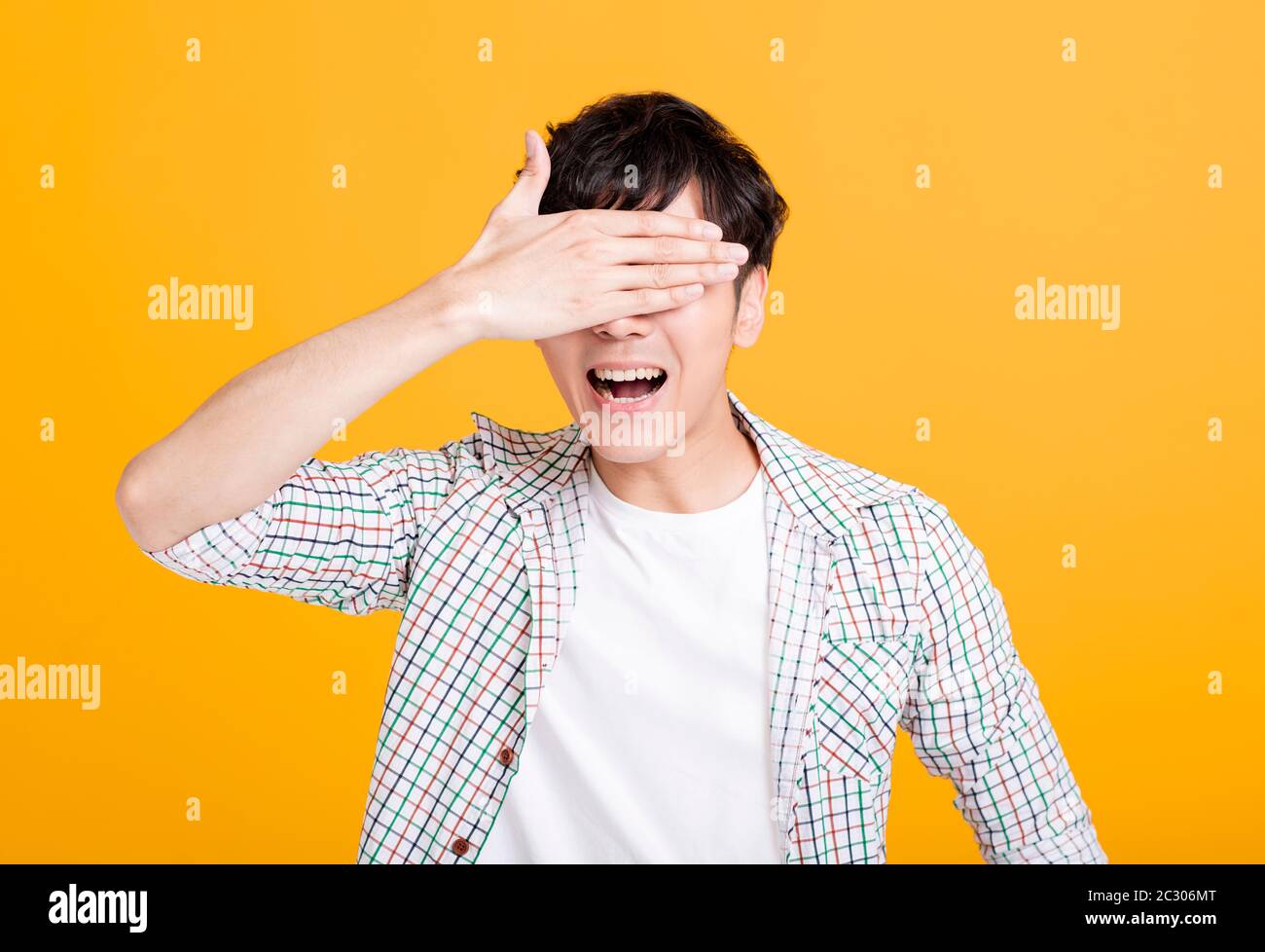 excited young man screaming and hand covering eyes Stock Photo - Alamy