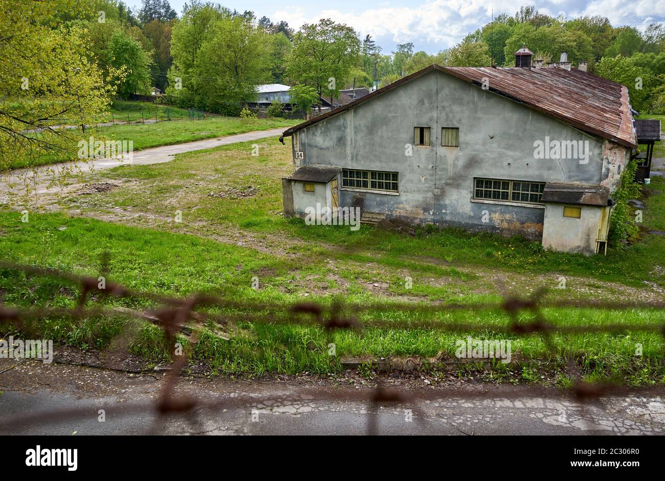 Old rural house with metal fence around it's garden Stock Photo