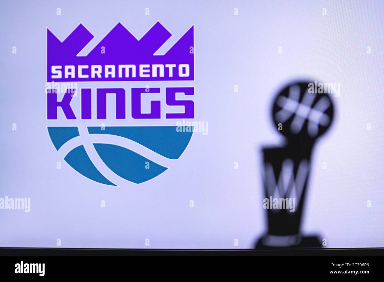 NEW YORK, USA, JUN 18, 2020: Sacramento Kings Basketball club on the white screen. Silhouette of NBA trophy in foreground. Stock Photo
