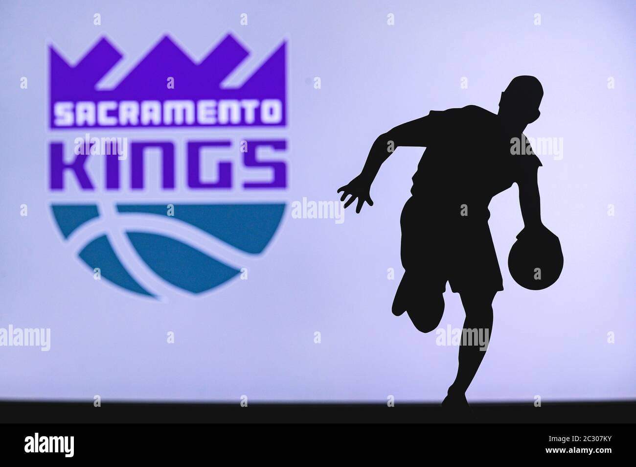 NEW YORK, USA, JUN 18, 2020: Sacramento Kings basketball club logo and silhouette of young basketball player. Sport wallpaper, white edit space in bac Stock Photo
