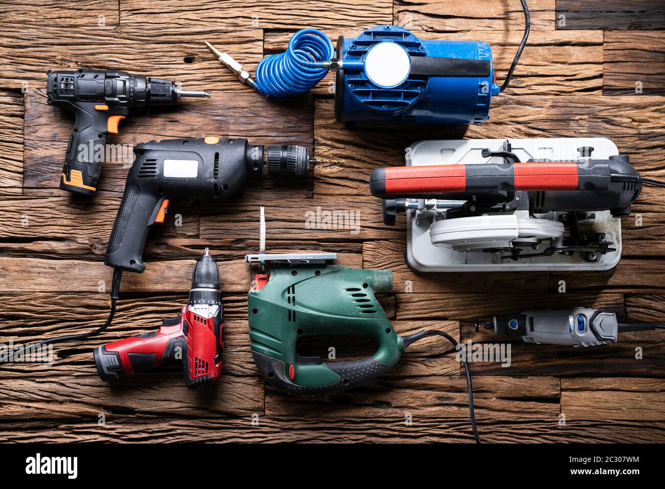 Various Power Tools Laying On Wooden Desk Stock Photo