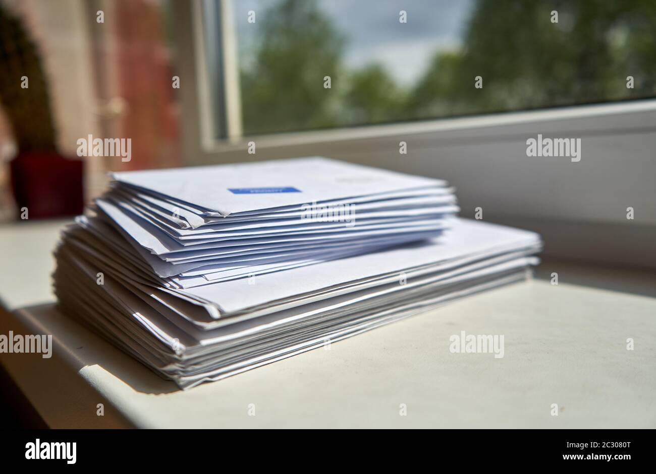 Pile of envelopes placed near the window at home Stock Photo