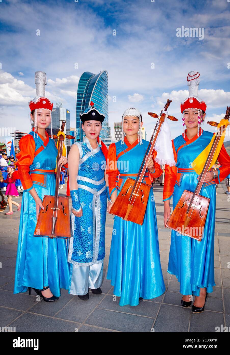 Mongolian girls wearing traditional costume and posing with national music instrument Morin huur, the Sukhbaatar square, Ulaanbaatar capital city Stock Photo