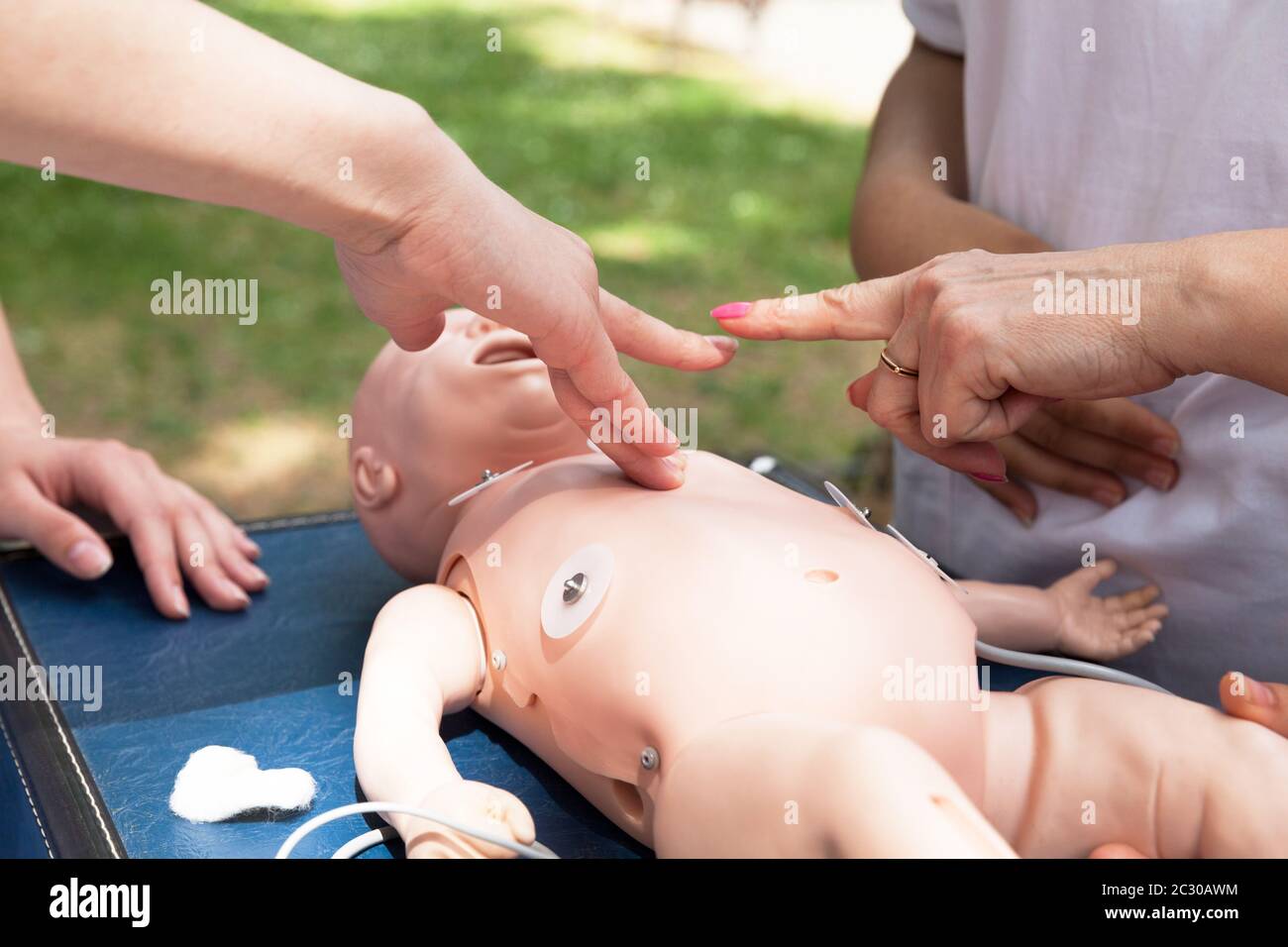 Paramedic performing CPR on baby training dummy Stock Photo