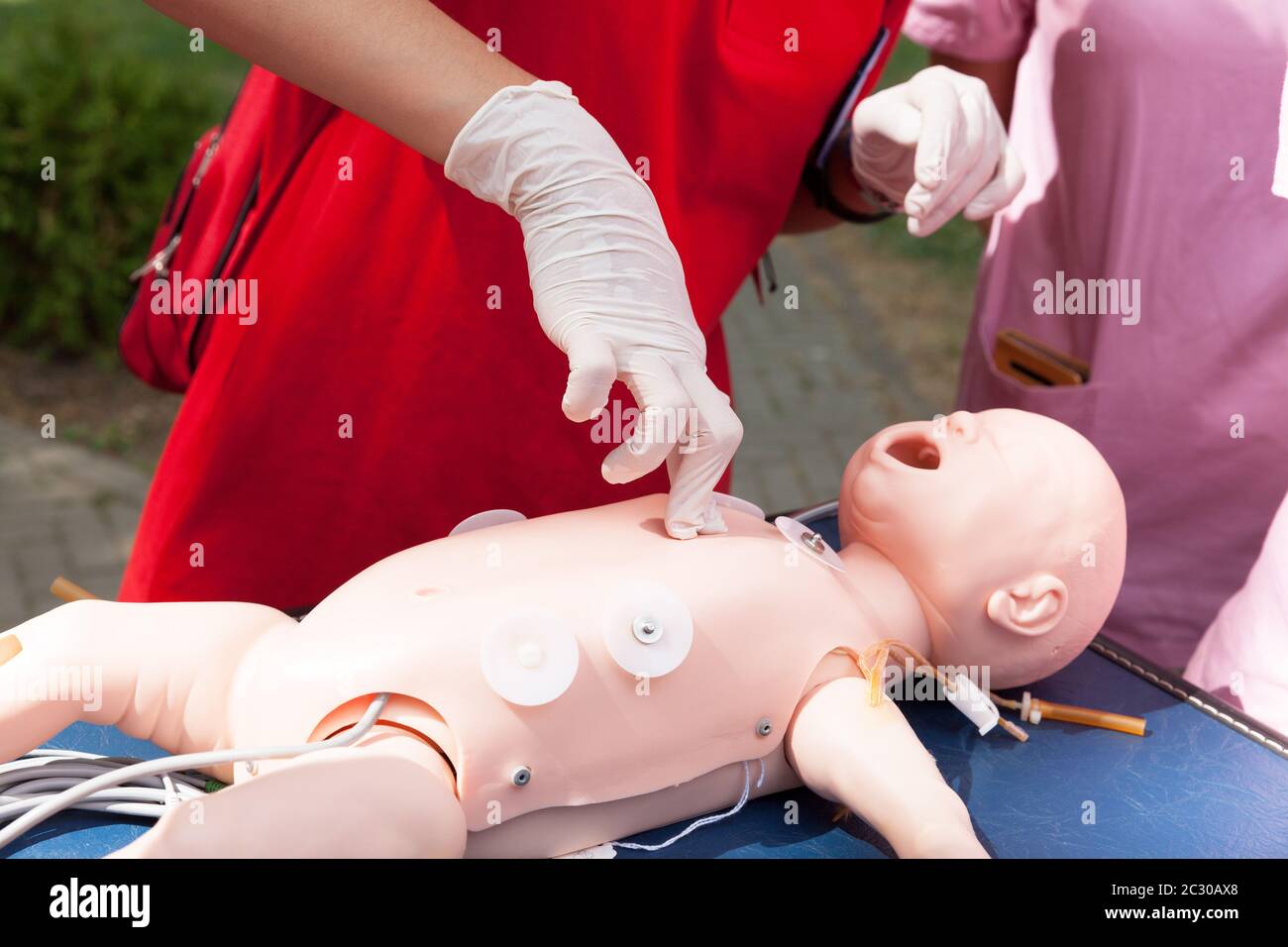 Paramedic performing CPR on baby training doll with two fingers chest  compression Stock Photo - Alamy