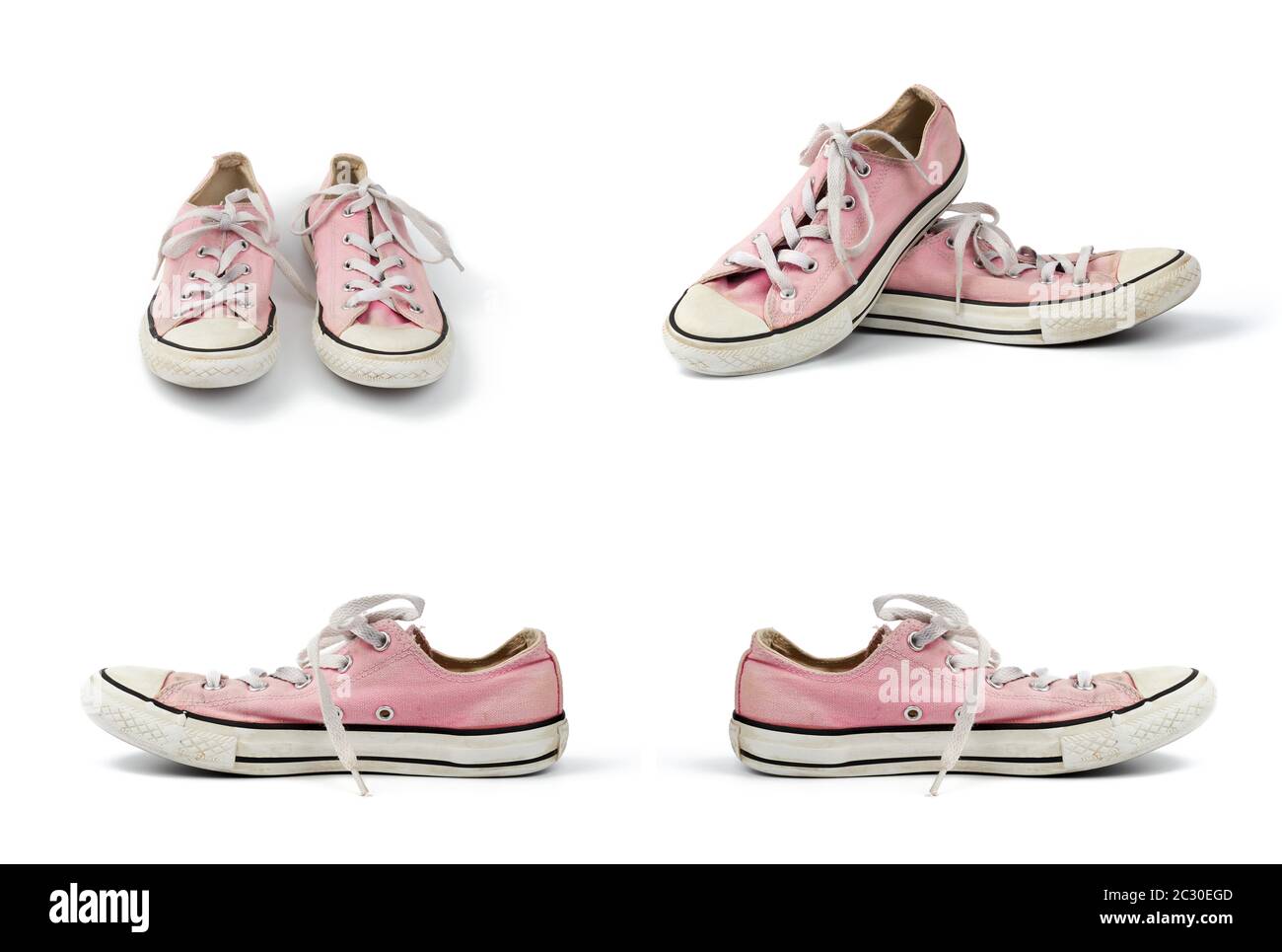 pair of light pink worn textile sneakers with laces isolated on a white ...