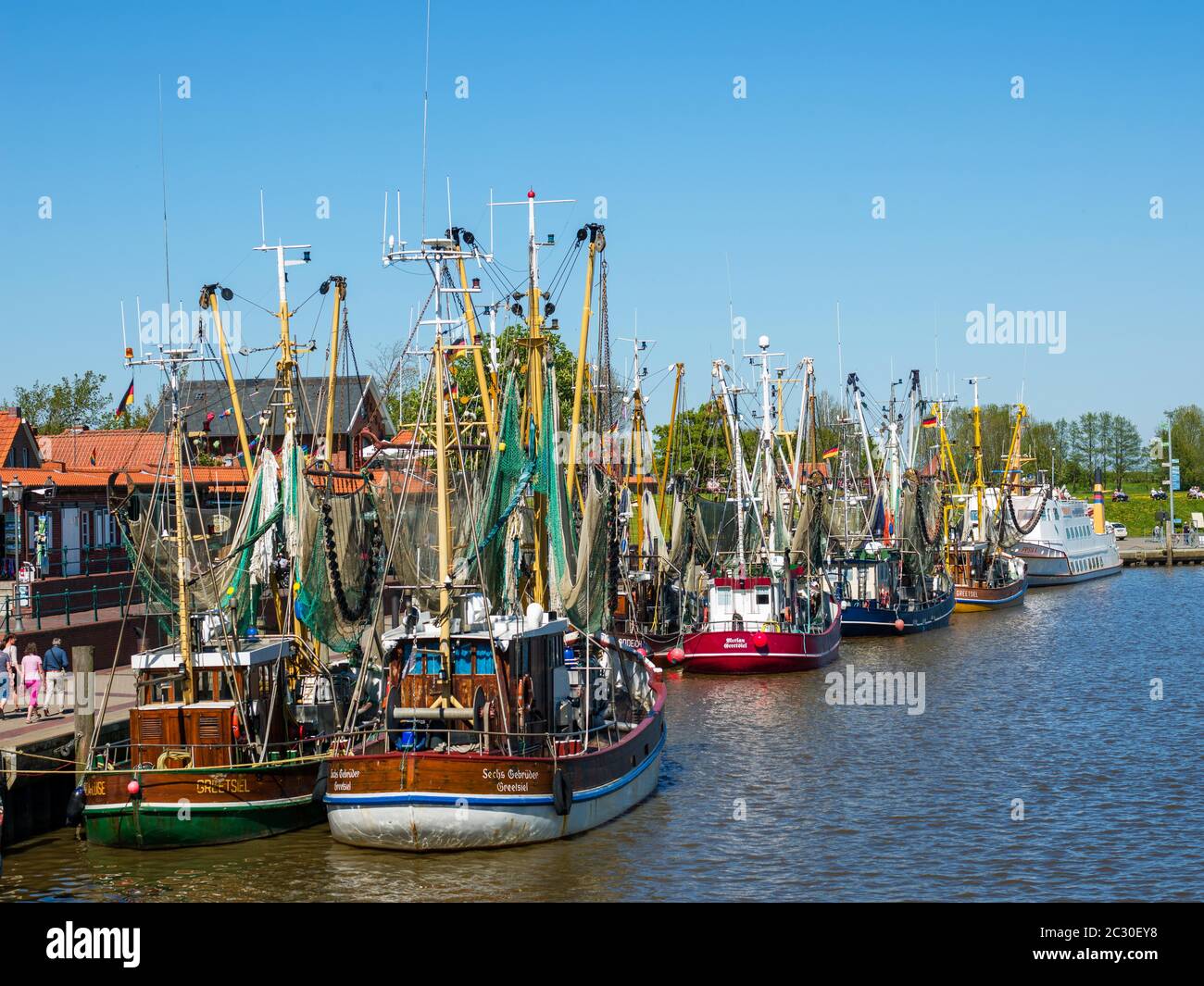 Colourful crab cutters in the fishing cutter harbour of Greetsiel, Krummhoern, East Frisia, Lower Saxony, Germany, landscape format Stock Photo