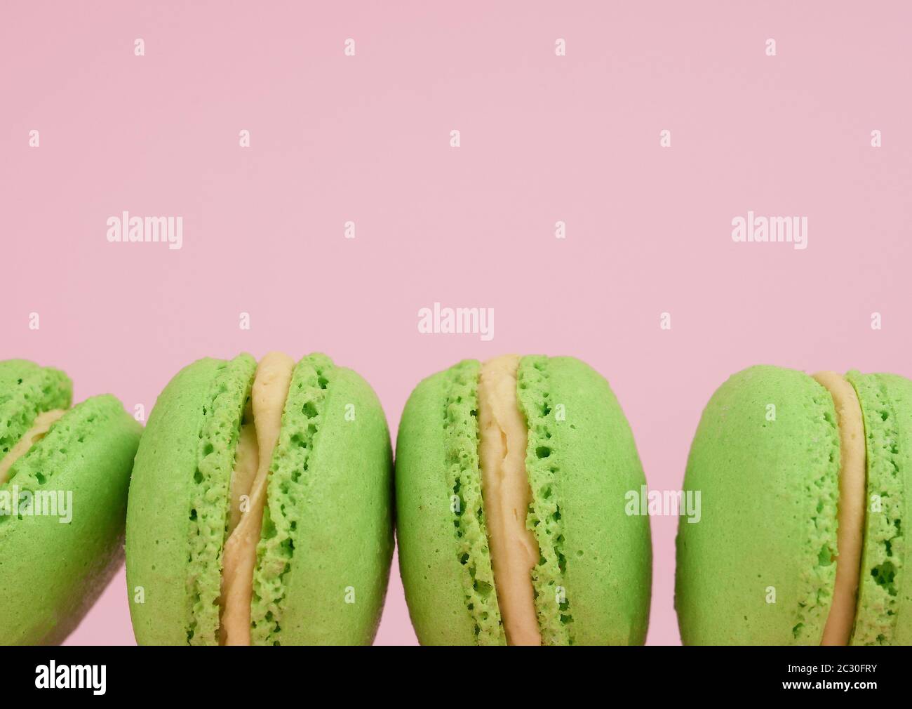 green round baked macaroon macarons on a pink background, delicious ...