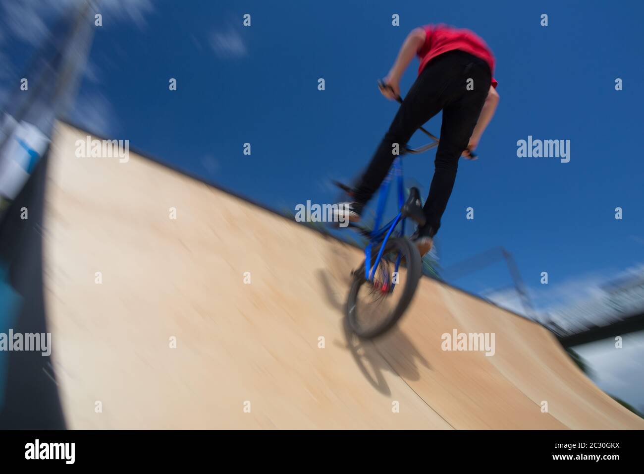 Bmx rider jumping over on a U ramp in a skatepark (motion blurred image) Stock Photo