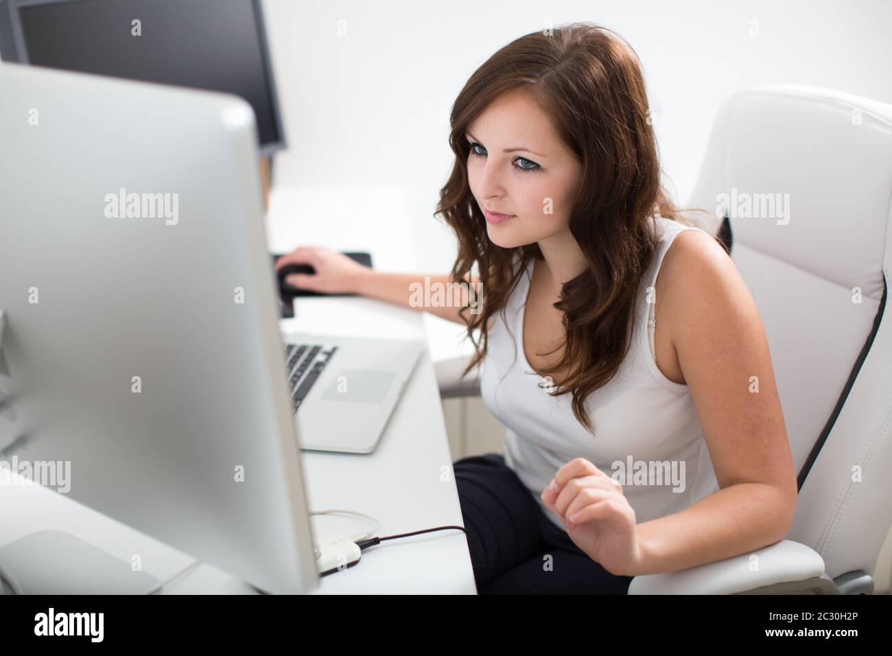 Young woman working on a computer in a home office Stock Photo