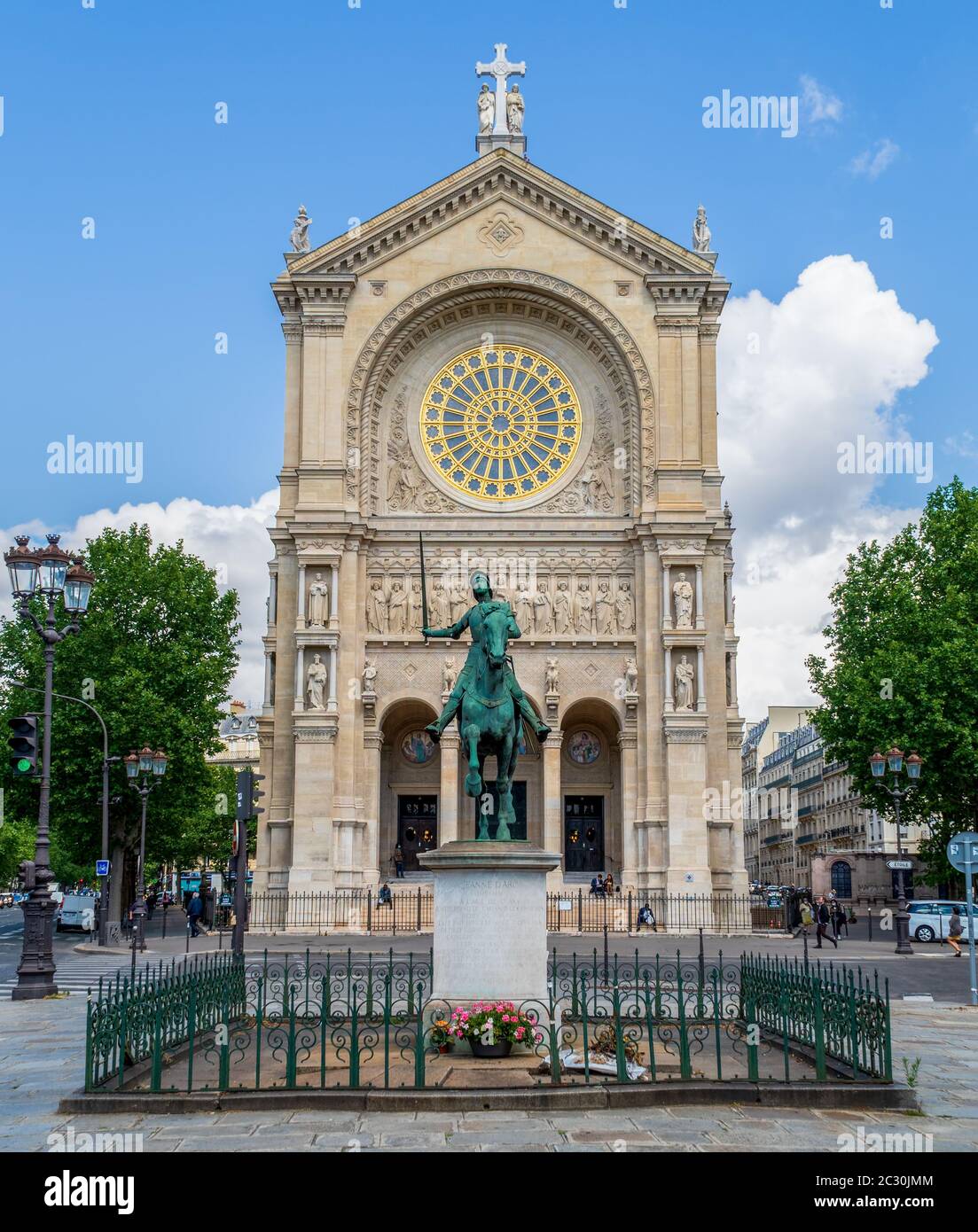 Statue of Jeanne d'Arc with Church of Saint Augustin in the background - Paris Stock Photo