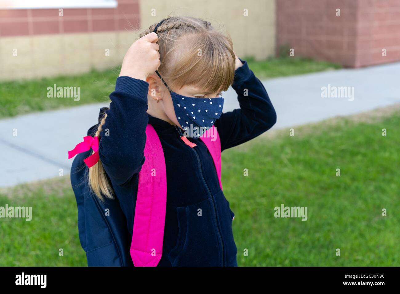 Young student caucasian girl wearing protective cotton mask for school. Return back to school, reopening, new life. Stock Photo