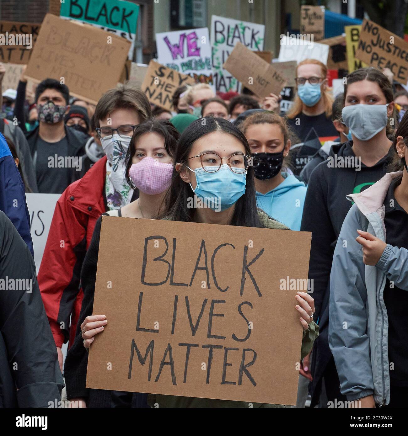 Many carrying signs, people march along a street during a June 7, 2020, Black Lives Matter protest in Eugene, Oregon. Stock Photo