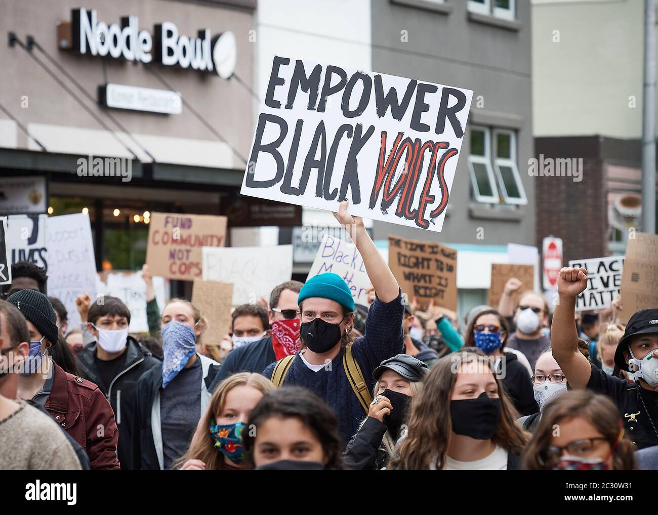 Many carrying signs, people march along a street during a June 7, 2020, Black Lives Matter protest in Eugene, Oregon. Stock Photo