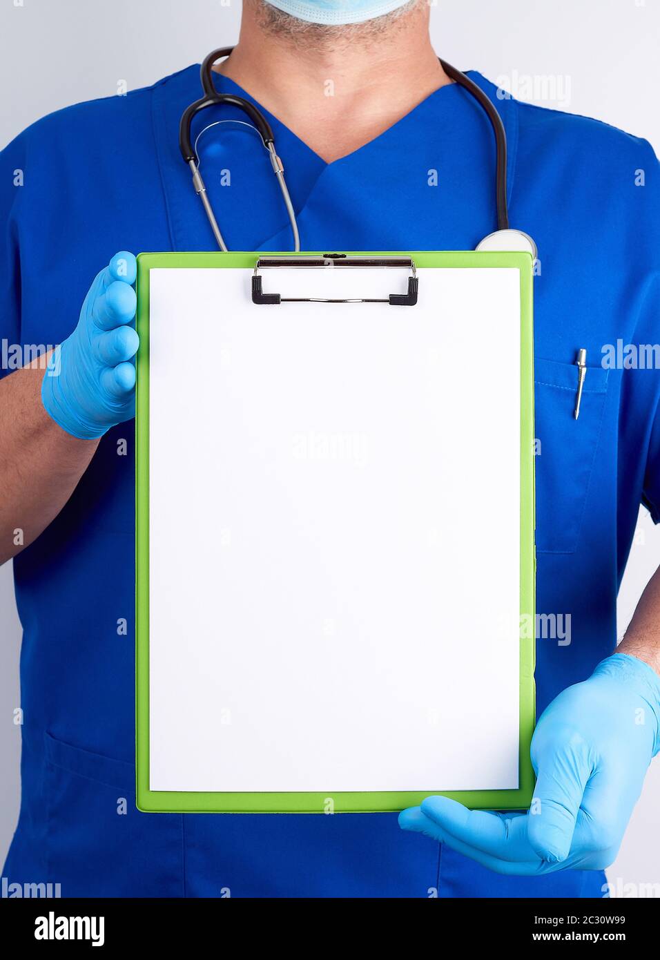 doctor in blue uniform and latex gloves holds a green holder for sheets ...