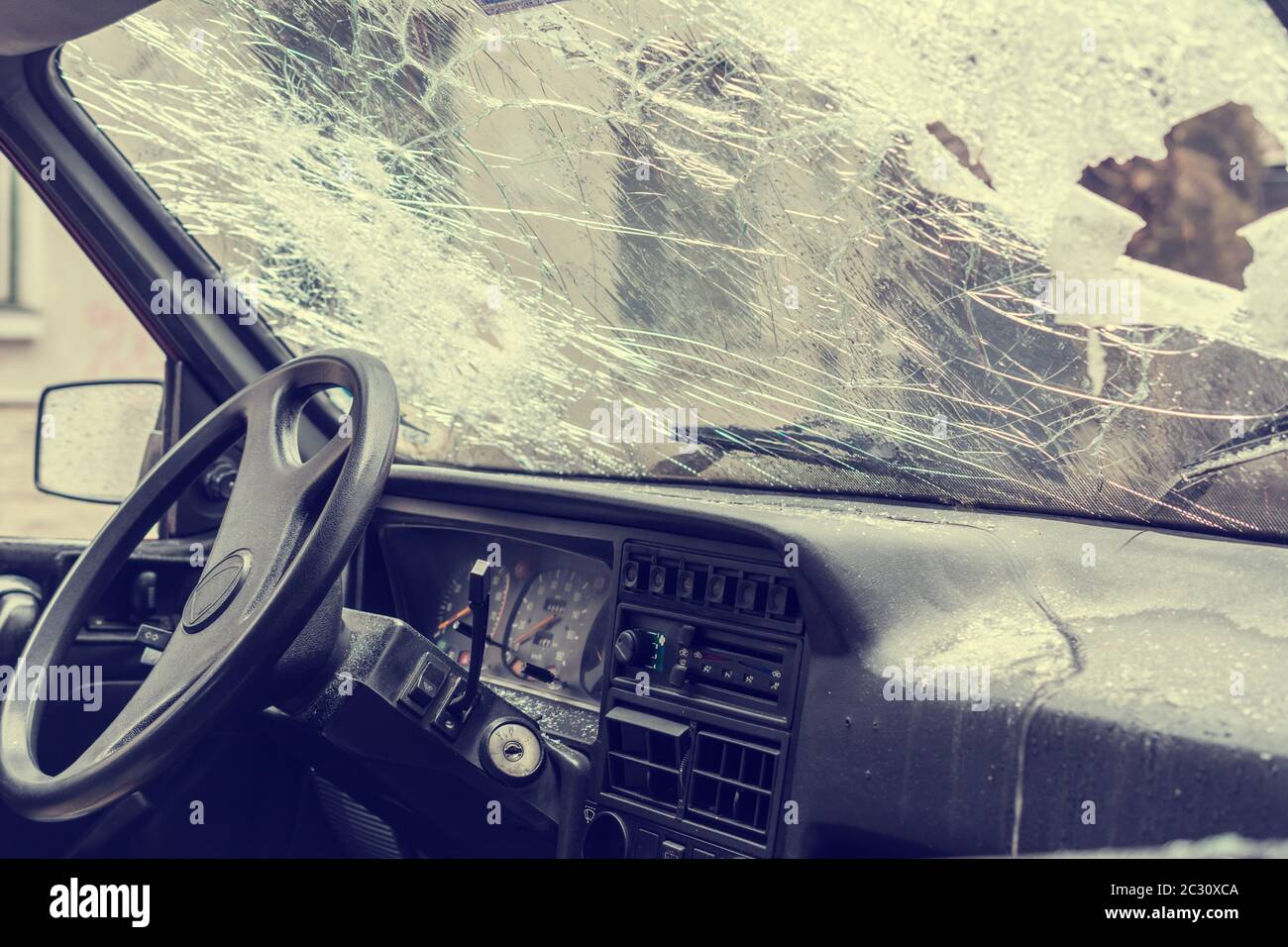 Broken car windshield smashed by a thief. Damaged glass from car theft