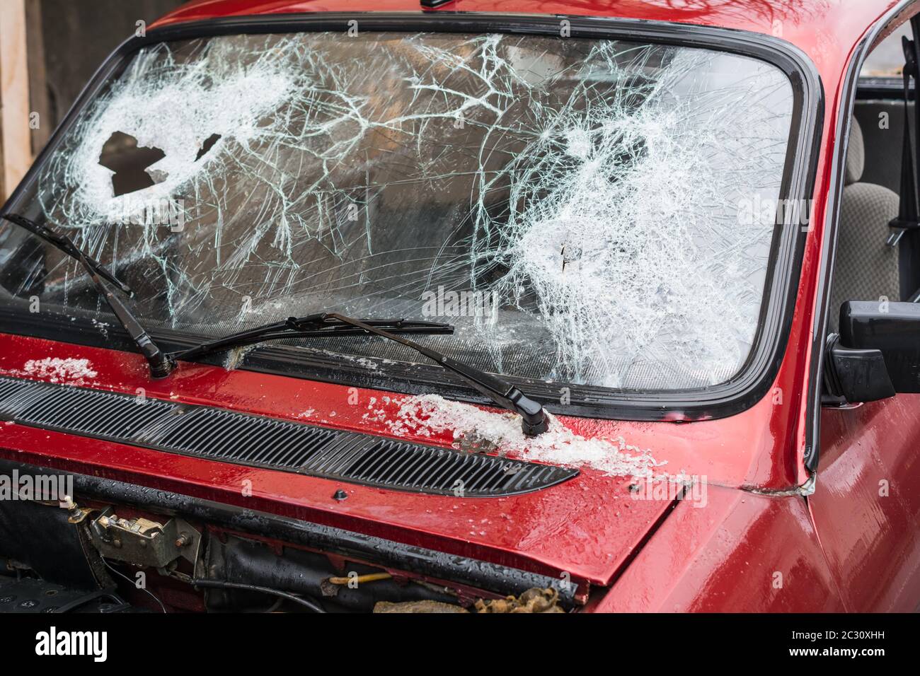 Broken car windshield smashed by a thief. Damaged glass from car theft