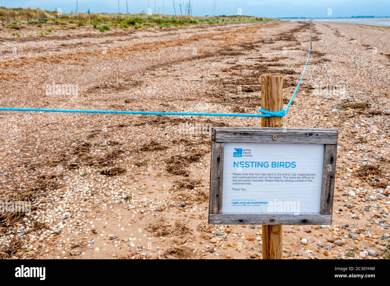 Area of Snettisham beach on the shores of the Wash roped off to protect nests of ringed plovers & oystercatchers. An RSPB sign warns of Nesting Birds. Stock Photo