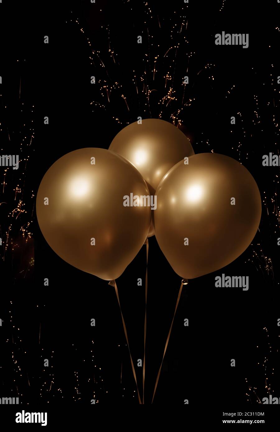 Golden luxury balloons on dark night sky with fireworks and place for celebratory text Stock Photo