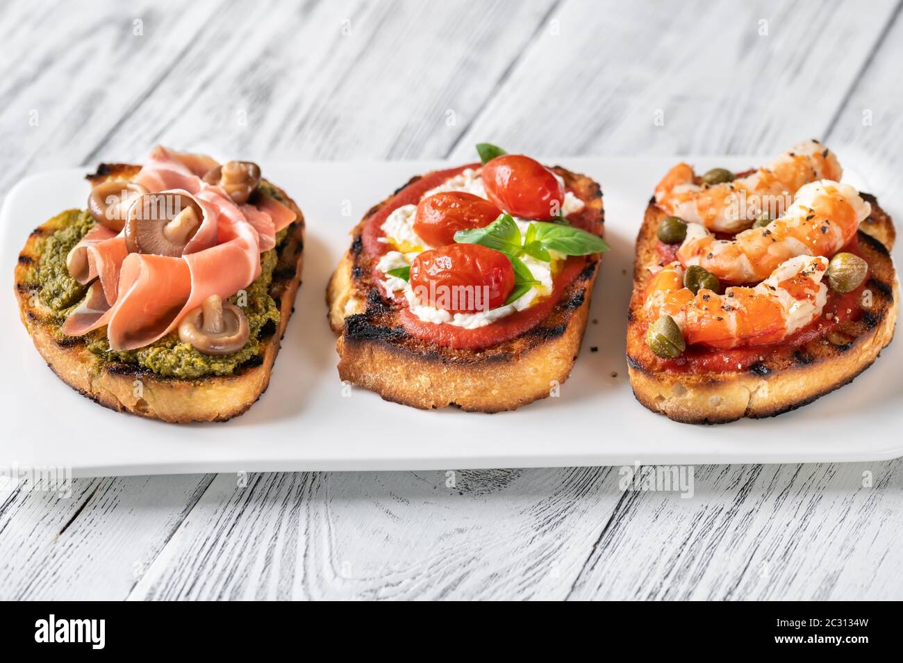 Assortment of Italian bruschettas with different toppings Stock Photo