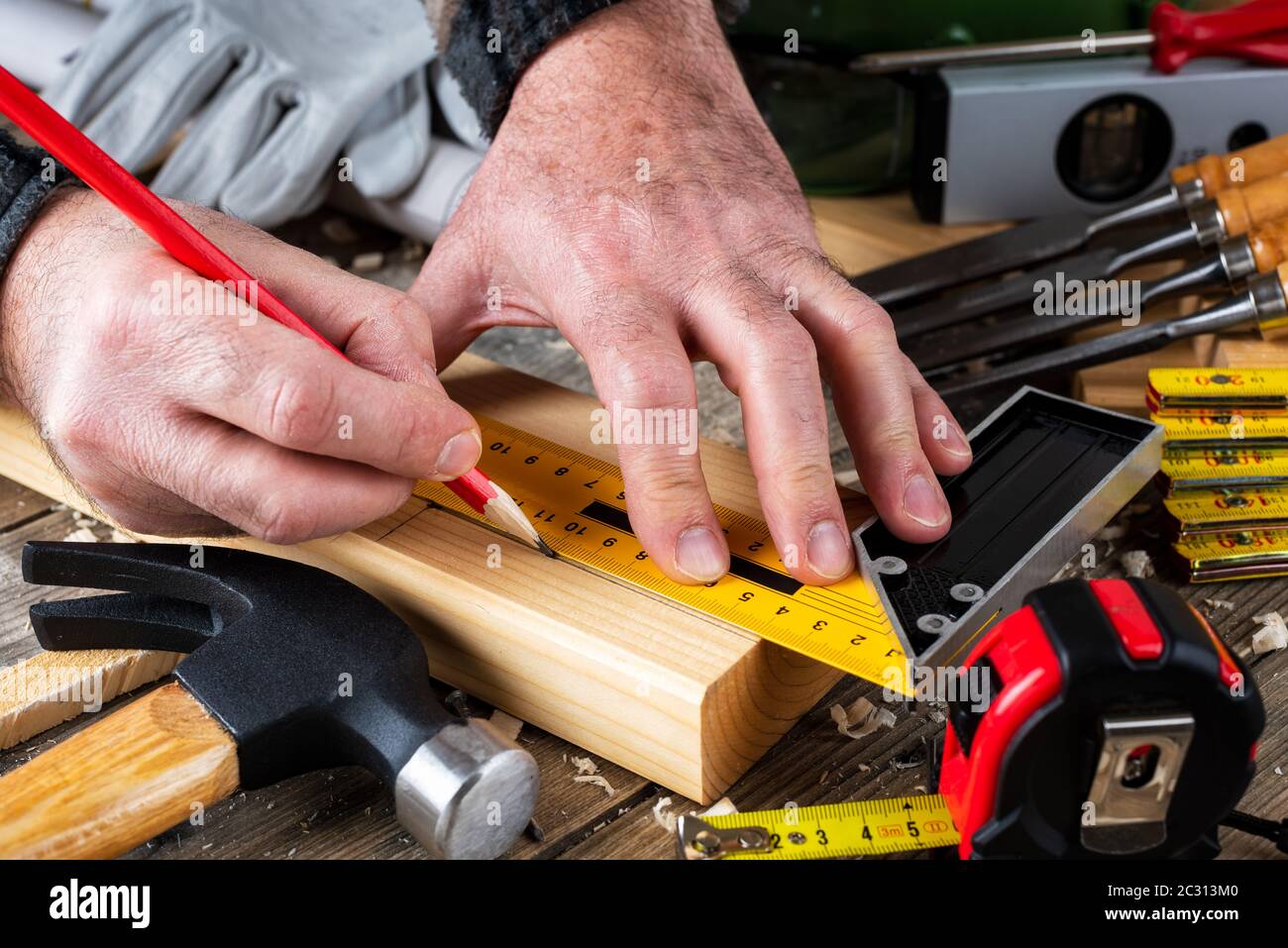 Top view. Carpenter with pencil and the carpenter's square draw the