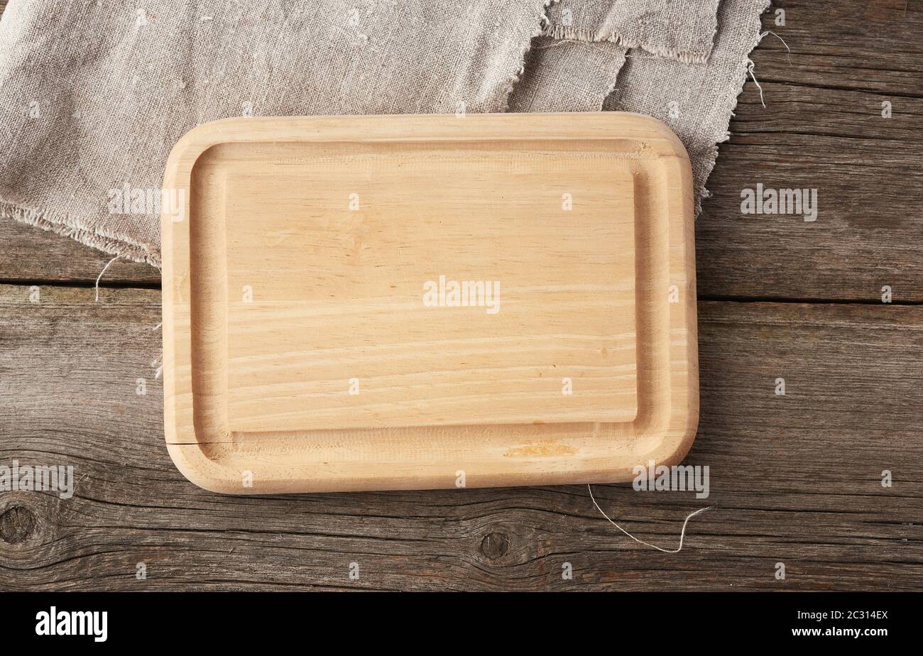 light beige rectangular empty cutting kitchen board on a wooden background from old boards, top view Stock Photo