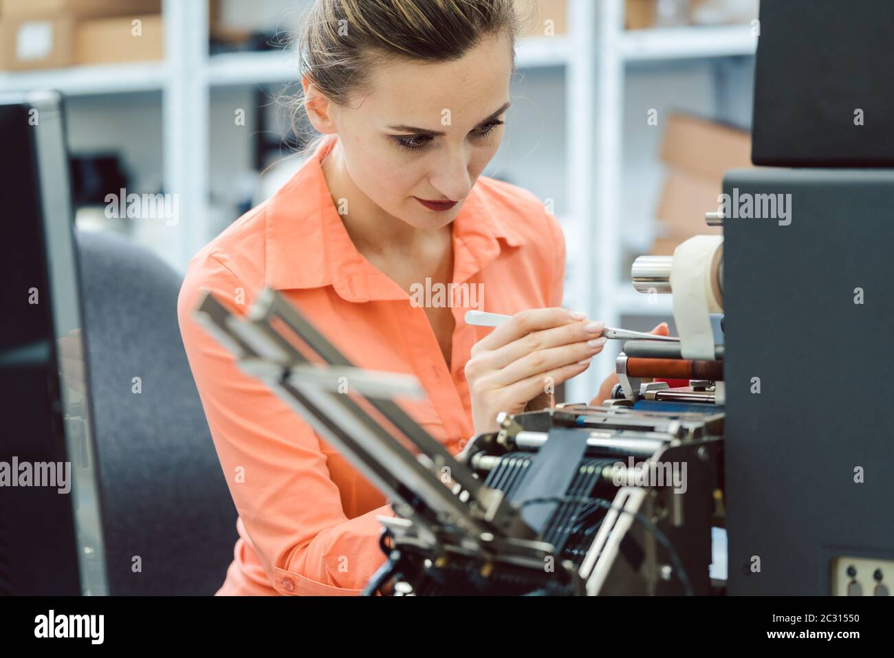 Insert Machine Operator Labels to be printed on being inserted into printing machine by woman ...