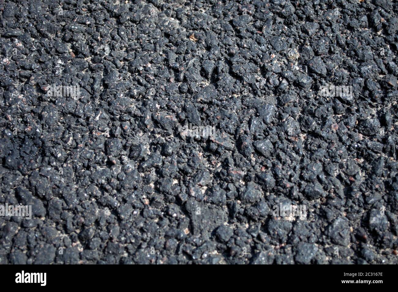 Grained asphalt. Stone hard road surface. Old technology of road
