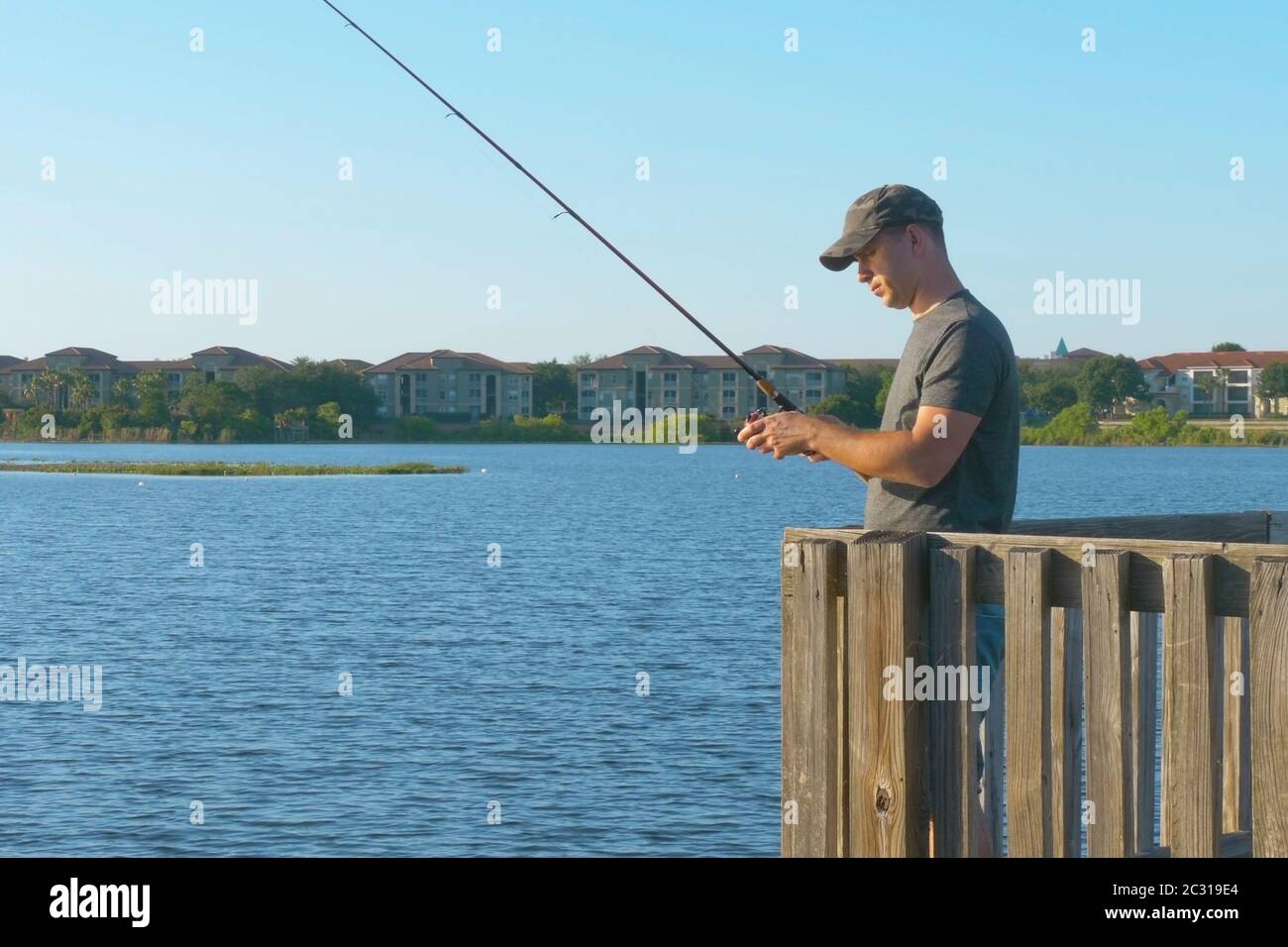 Fisherman cast fishing rod in lake or river water. Stock Photo
