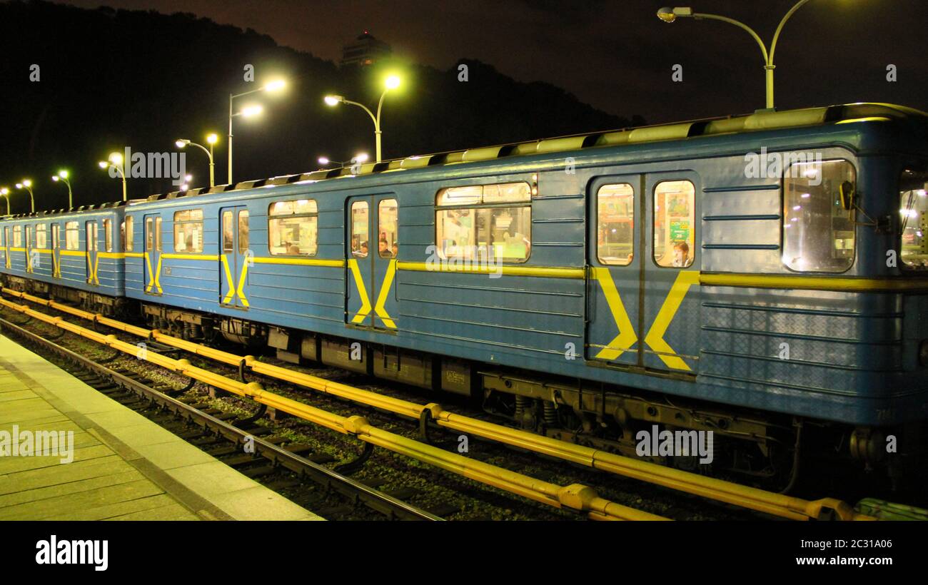 Electric train leaving station in subway in evening. Train leaving metro station. Underground train Stock Photo