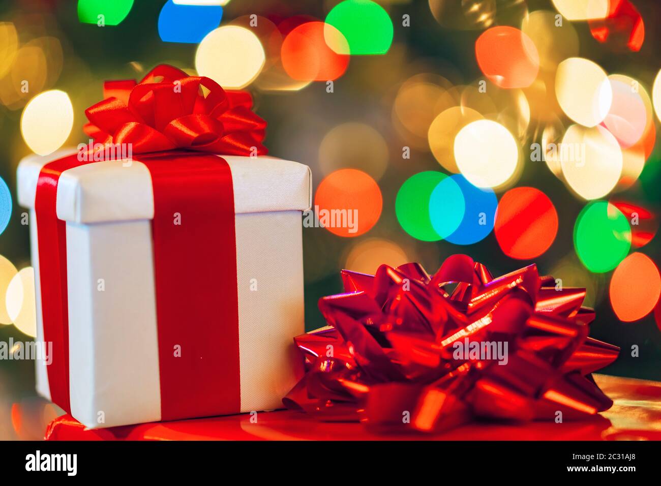 gift boxes with ribbon and bow on holiday lights background Stock Photo