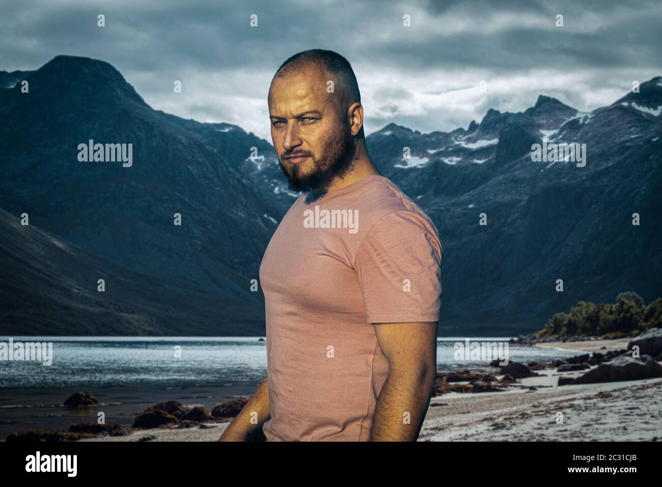 severe brutal man on a background of mountains and a fjord Stock Photo