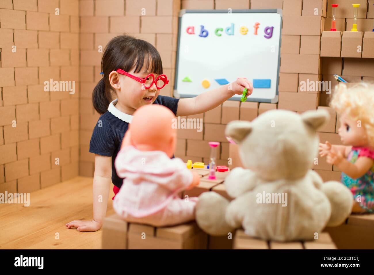 toddler girl pretend play as a teacher at home Stock Photo Alamy