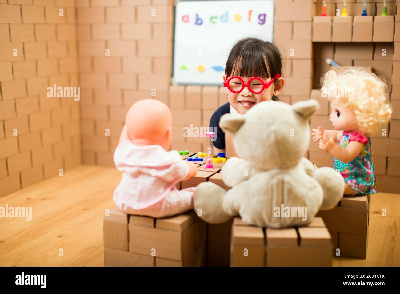 toddler girl pretend play as a teacher at home Stock Photo Alamy