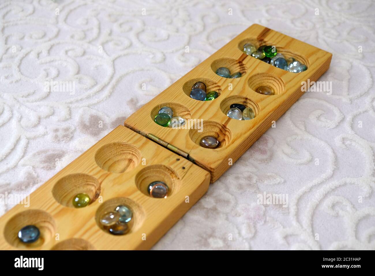 old intelligence games, wooden mancala game, a person playing mancala, Stock Photo