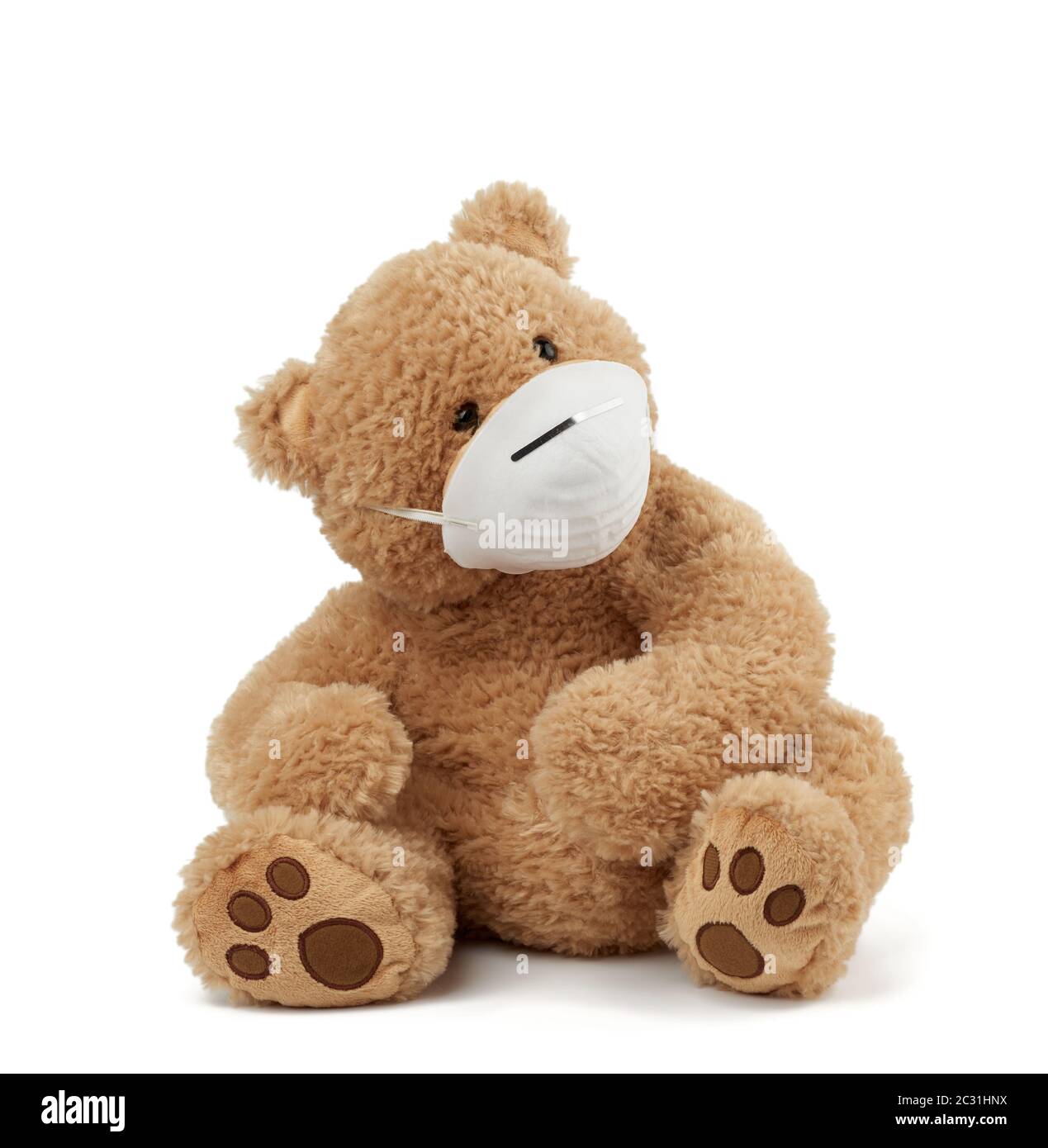 big teddy bear are sitting in medical masks on a white background, concept of protection from respiratory disease, virus and individual respiratory pr Stock Photo