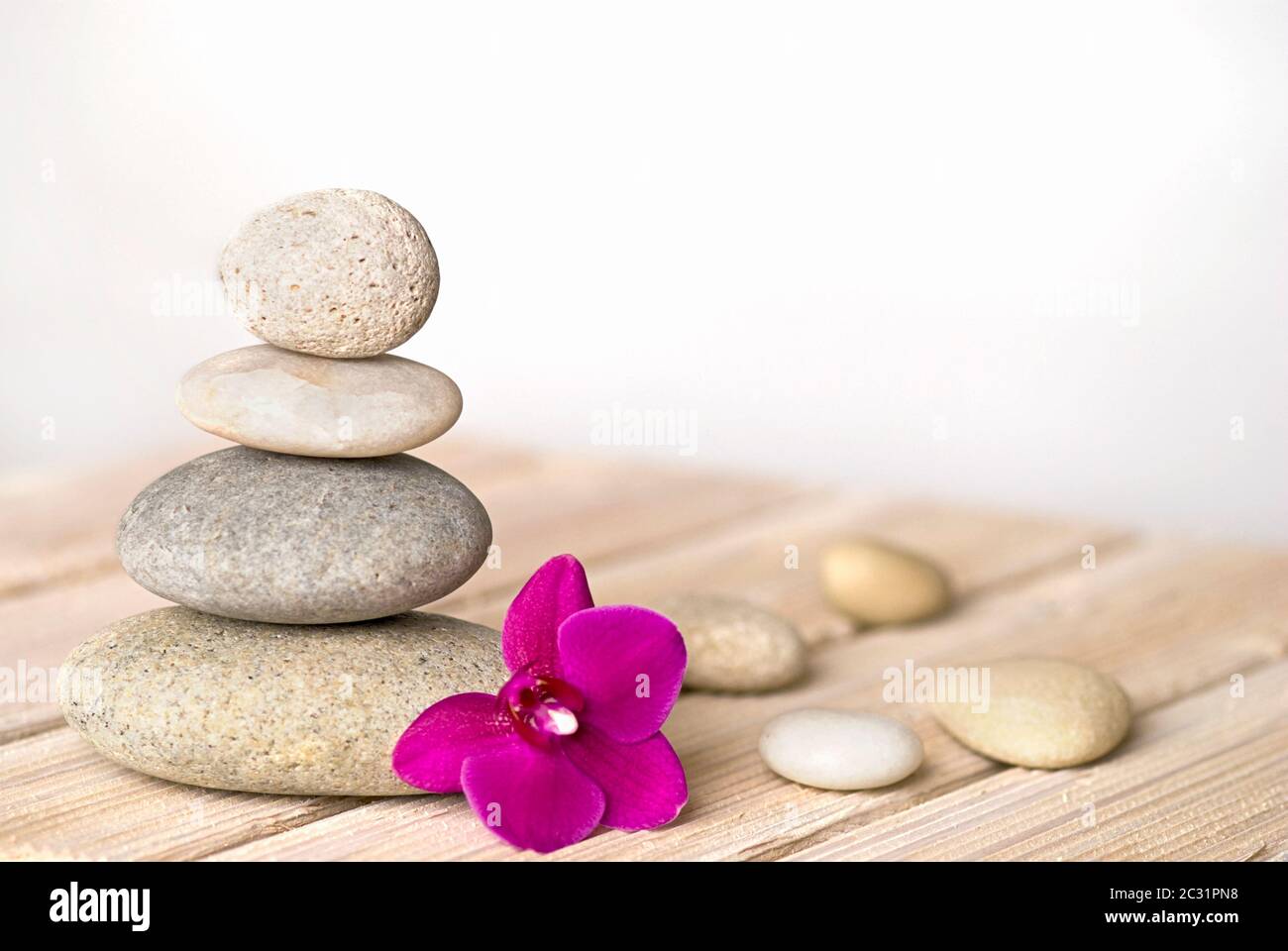 zen style still life with pink orchid flower and stone cairn Stock Photo