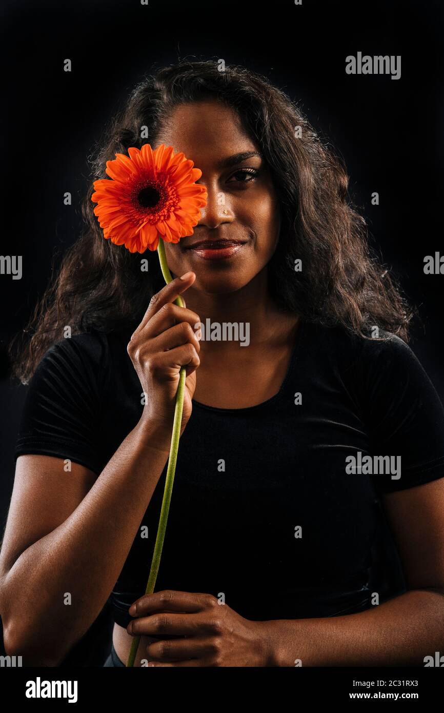 Smiling woman holding flower Stock Photo