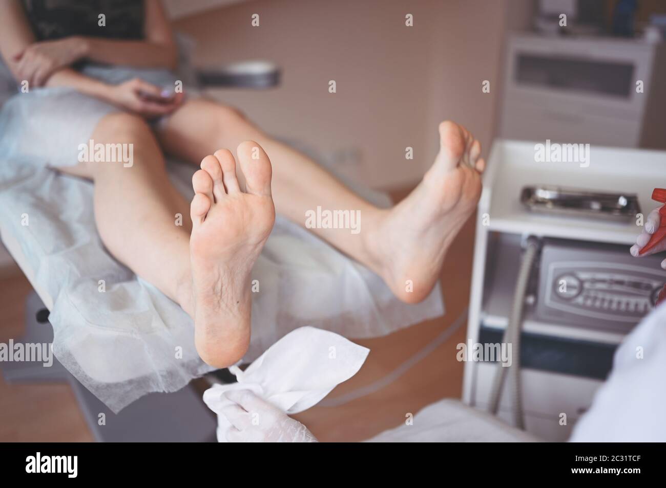 Podiatrist using grinding equipment and making procedure polish for feet  pedicure. Podology beautician in white gloves cleaning skin of client legs  Stock Photo - Alamy