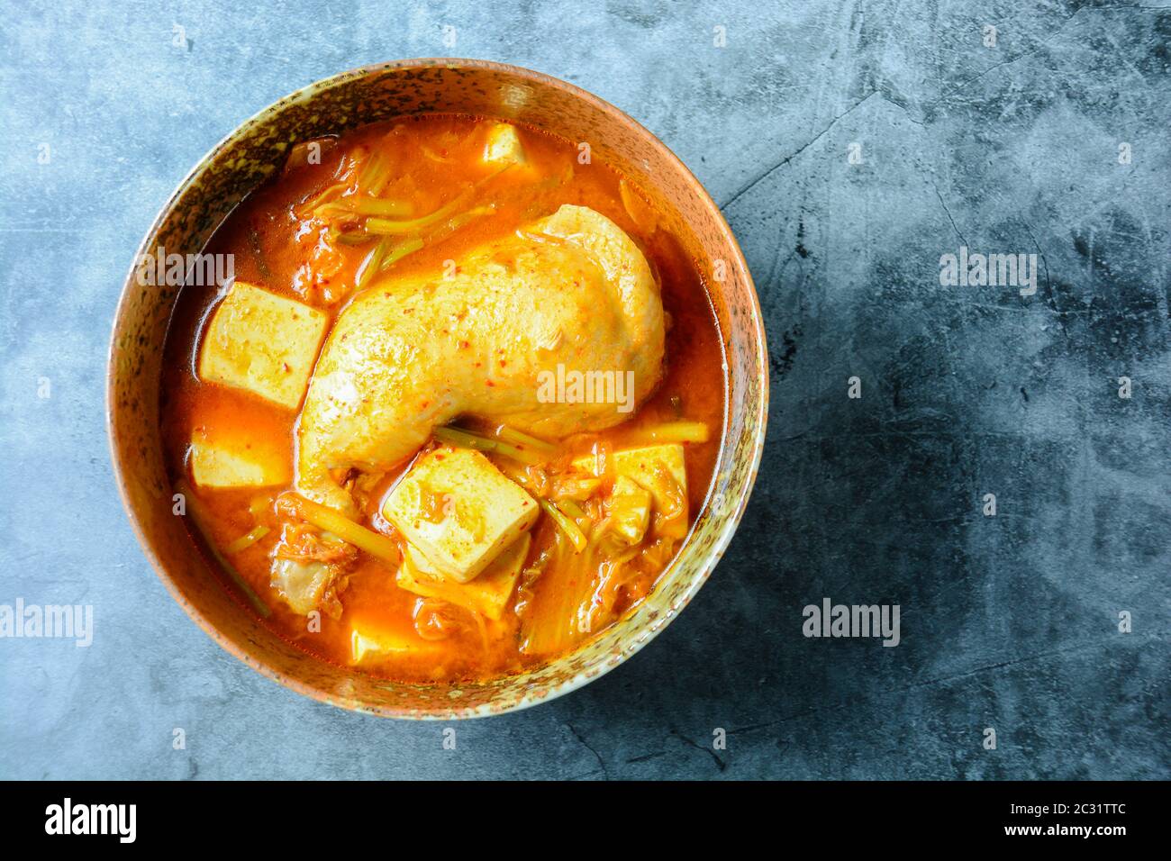 Korean traditional Kimchi soup with chicken and soft tofu Stock Photo