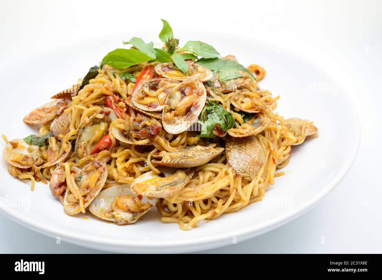 Stir fried noodles with clams and herbs, hot and spicy dish Stock Photo