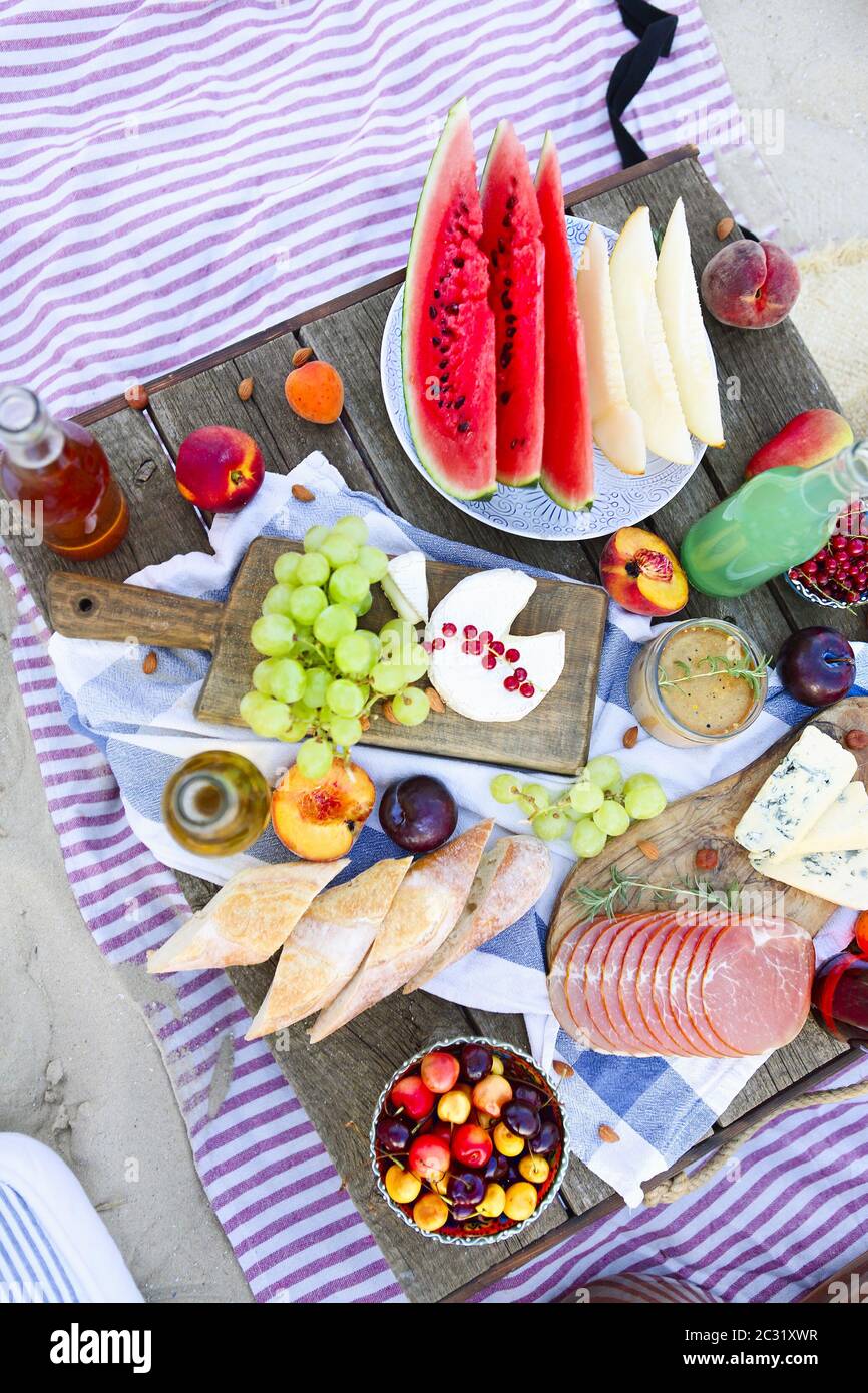 Picnic on the beach at sunset in the style of boho Stock Photo